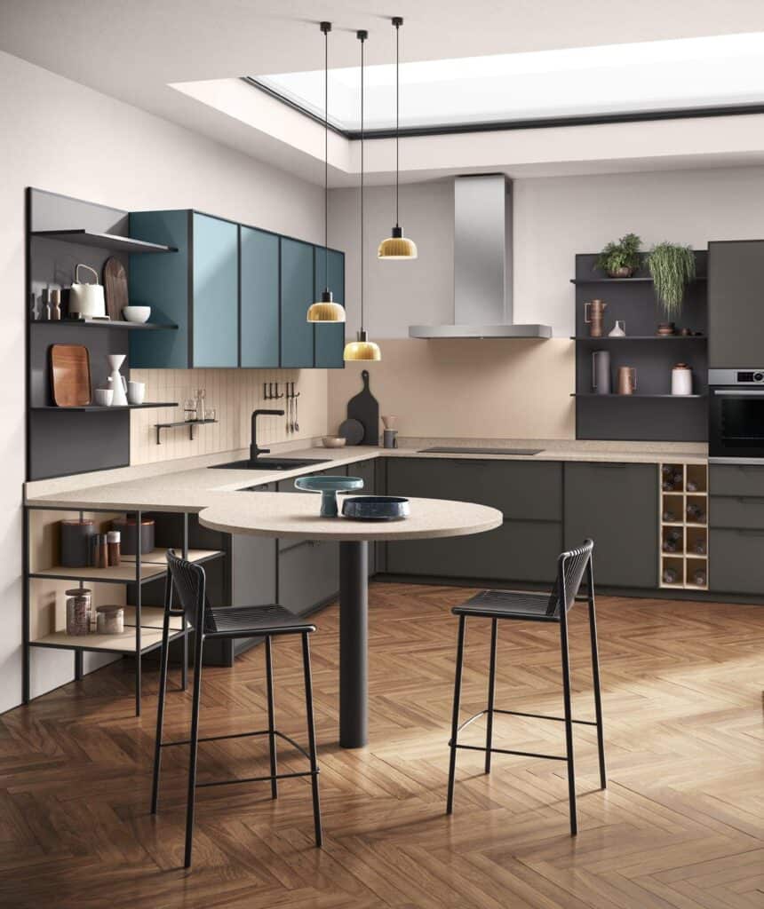 Modern kitchen with teal cabinets, open shelving, a round dining counter with two stools, and pendant lights, featuring a wooden herringbone floor.