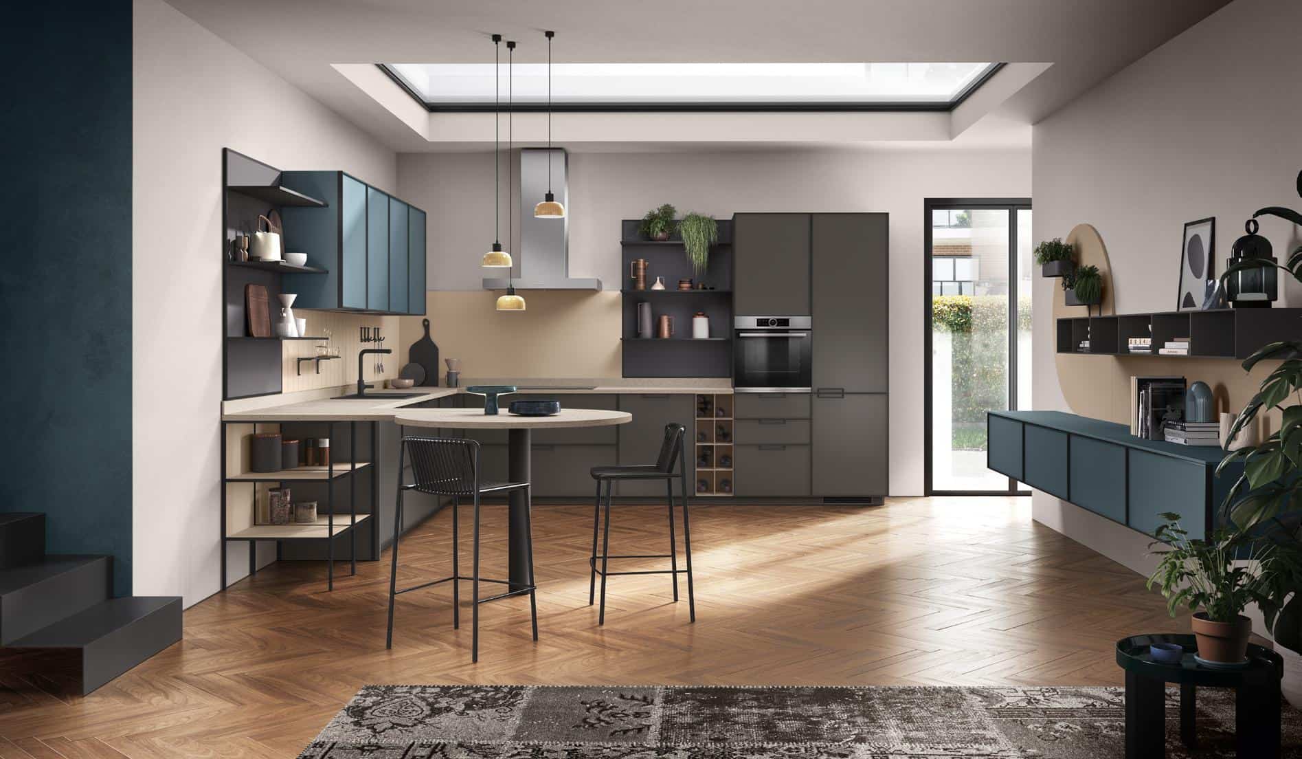 Modern kitchen with teal and gray cabinets, wooden herringbone floor, a central island with chairs, and pendant lights.
