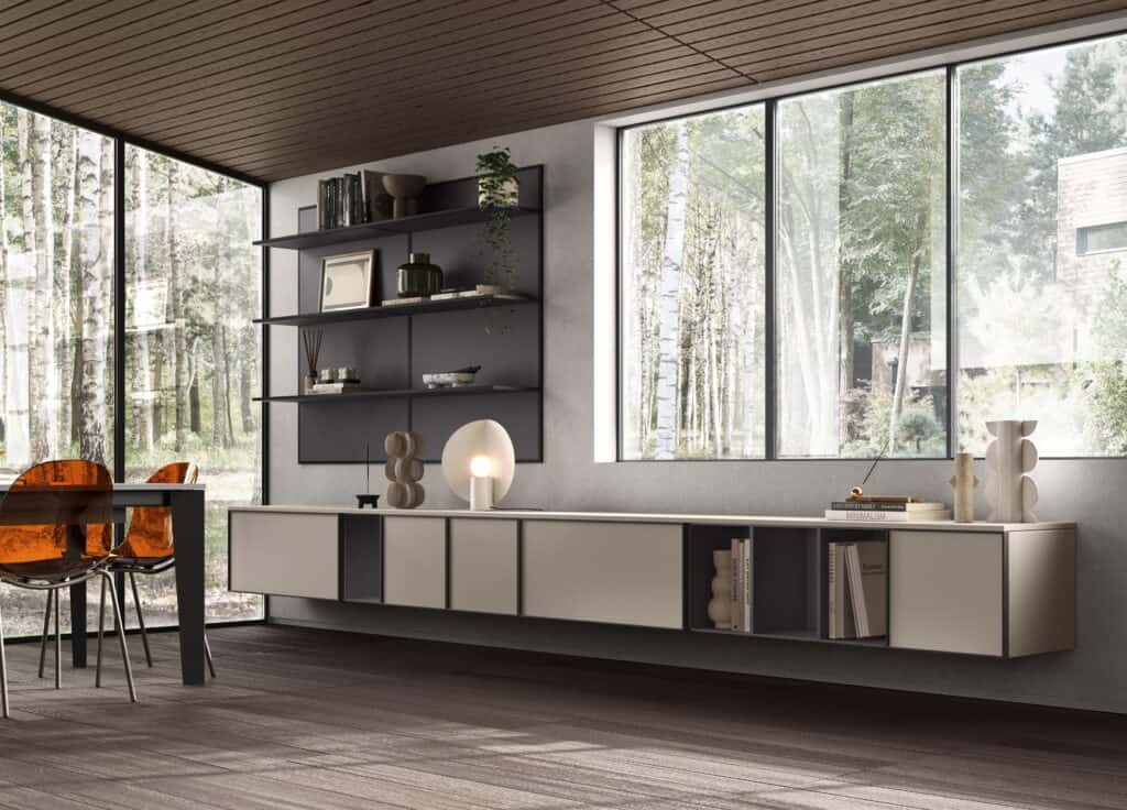 Modern interior with minimalist shelving, a cream-colored console, and a glass table with amber chairs beside large windows overlooking a forest scene.