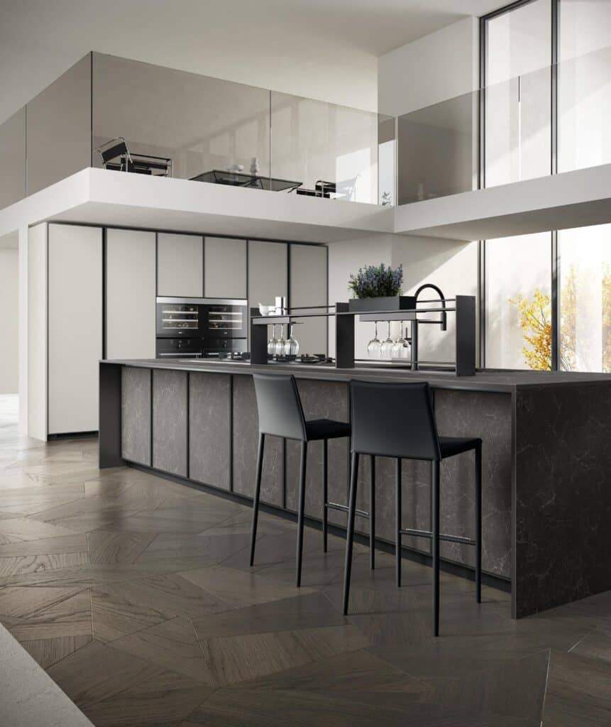 Modern kitchen with a minimalist design, featuring a long dark marble island, two tall black chairs, built-in appliances, and overhead glass railing above a mezzanine.