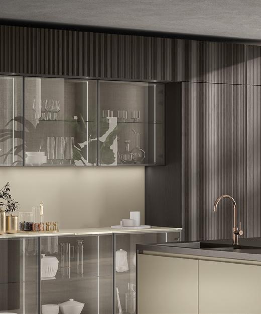 Modern kitchen with glass cabinets, dark paneling, and a sleek sink.