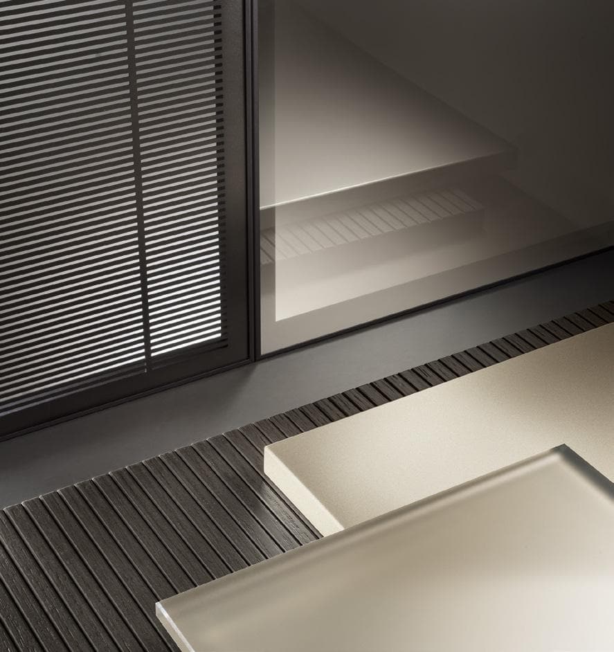 Modern architectural interior with textured flooring, matte panels, and reflective glass surfaces.