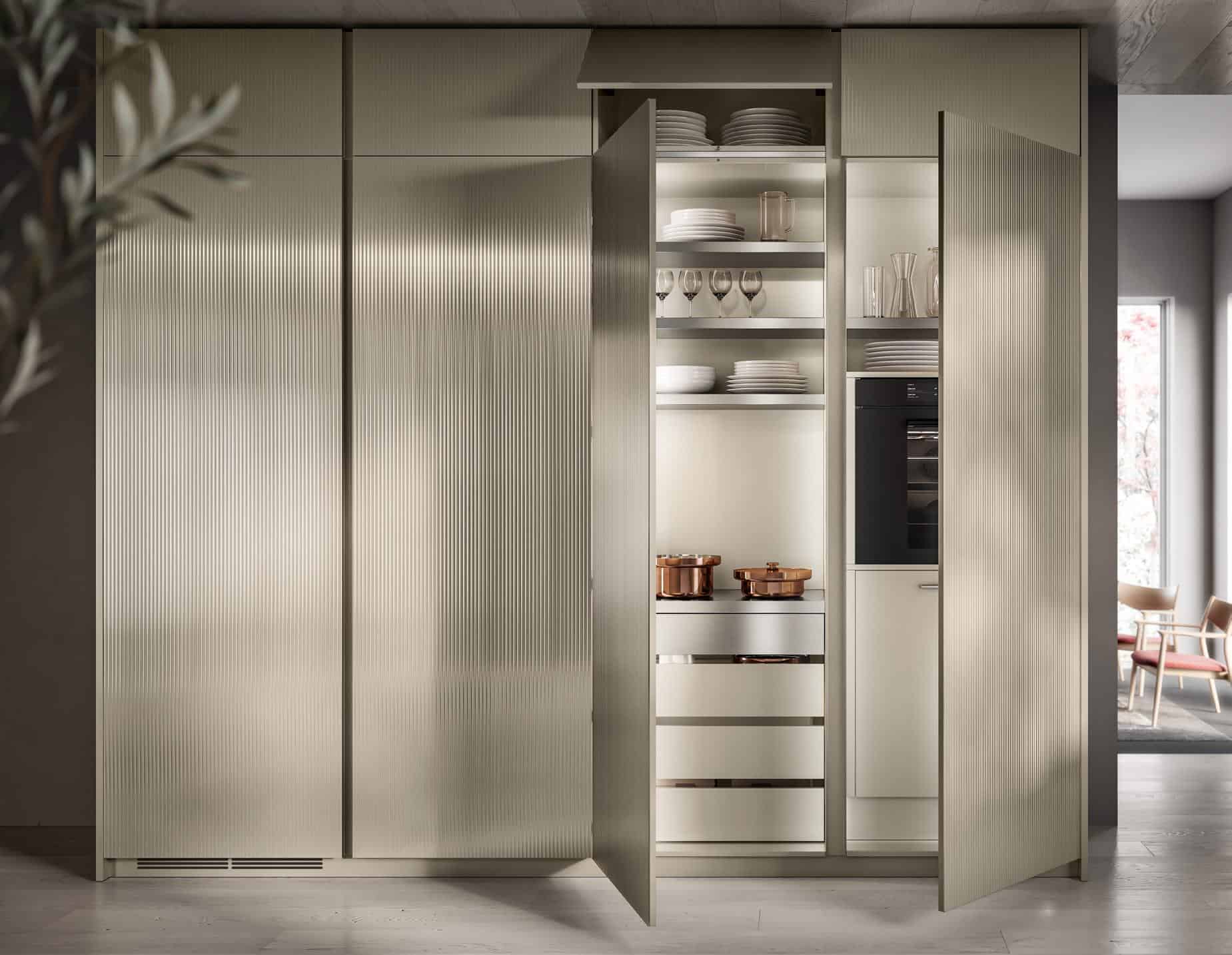 Modern kitchen with open cabinets showing shelves of dishes and glassware, and built-in oven.