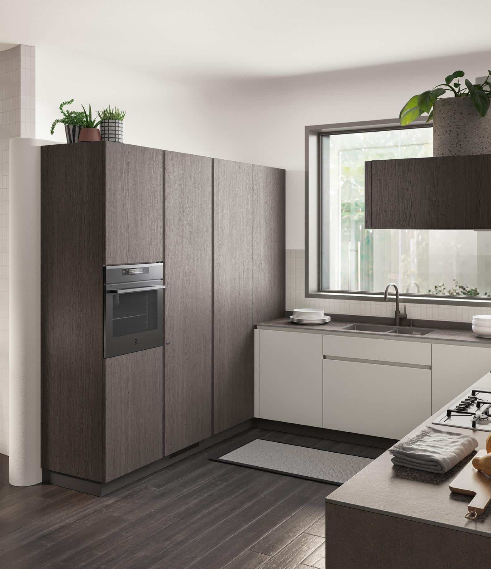 Modern kitchen with dark wood flooring, grey cabinets, integrated oven, large window, and plants.