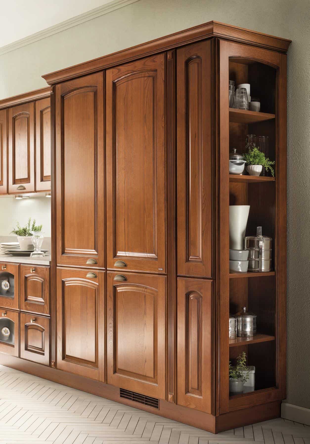Wooden kitchen cabinets with an integrated open shelf displaying dishes and plants.