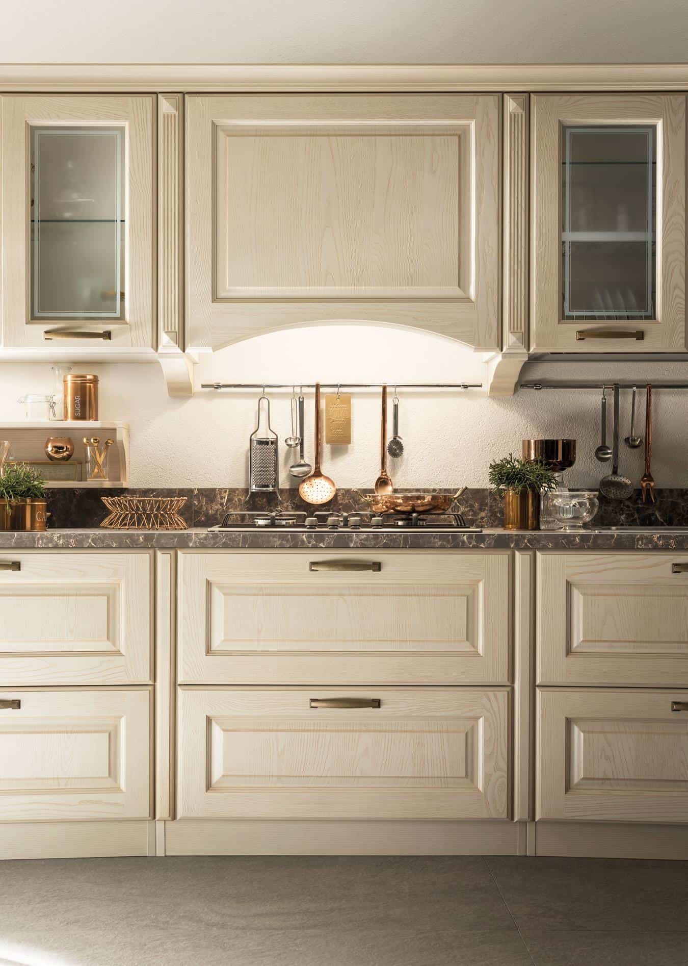 Elegant kitchen with light wood cabinets, dark marble countertop, and copper accents.