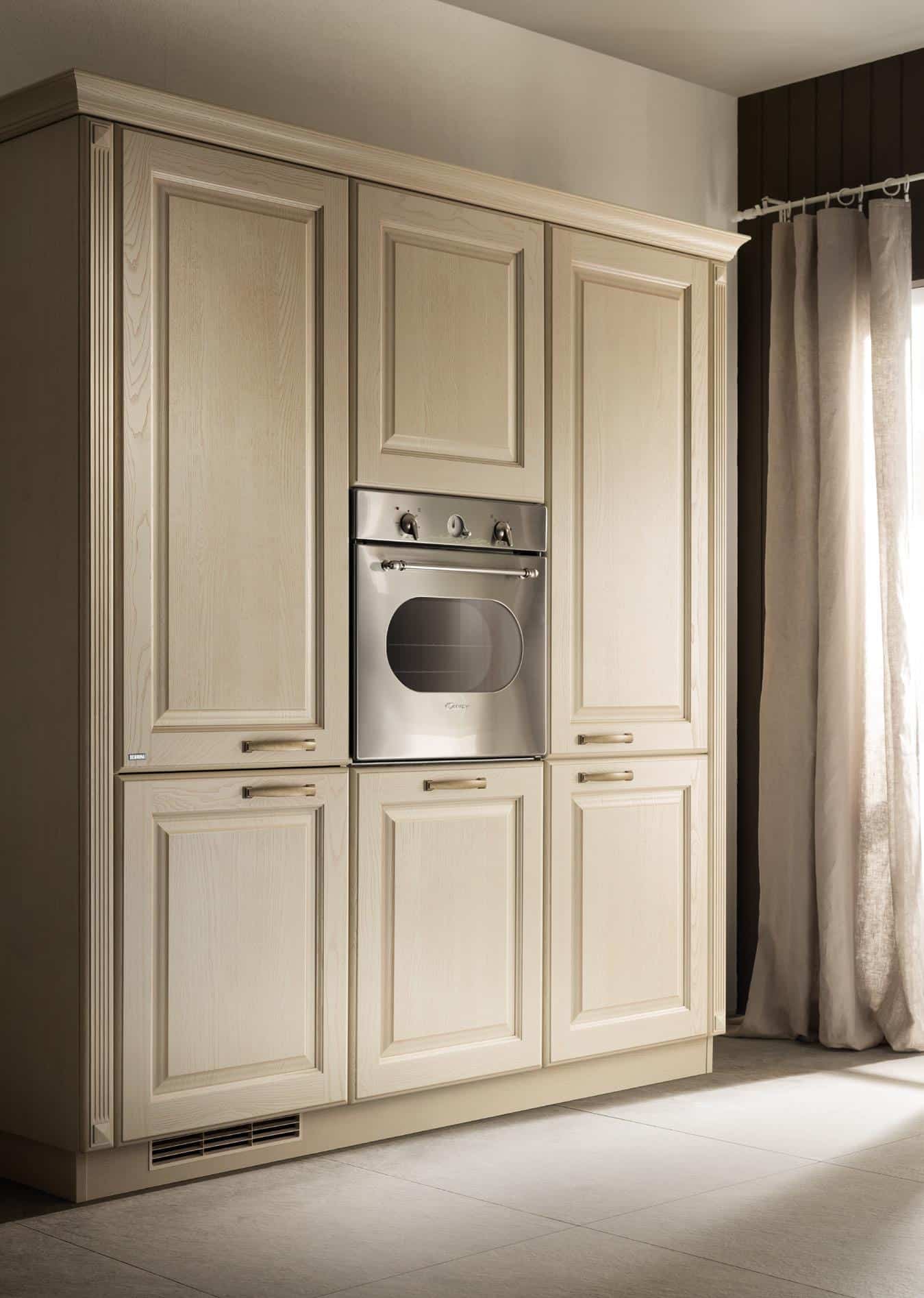 A kitchen with light wood cabinetry and a built-in stainless steel oven.