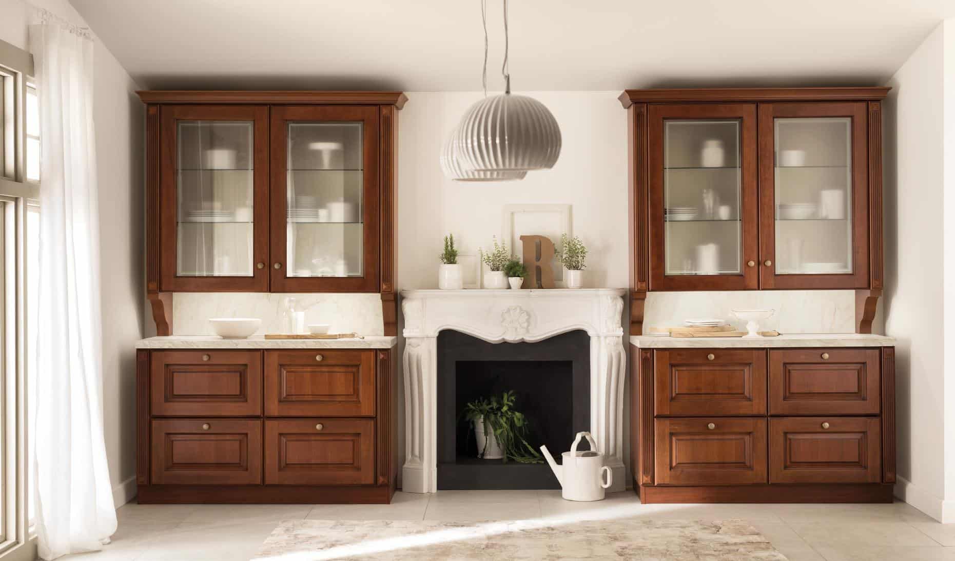 Elegant kitchen with dark wooden cabinets, a white ornate fireplace in the center, a modern pendant light, and decor items including potted plants and a watering can.