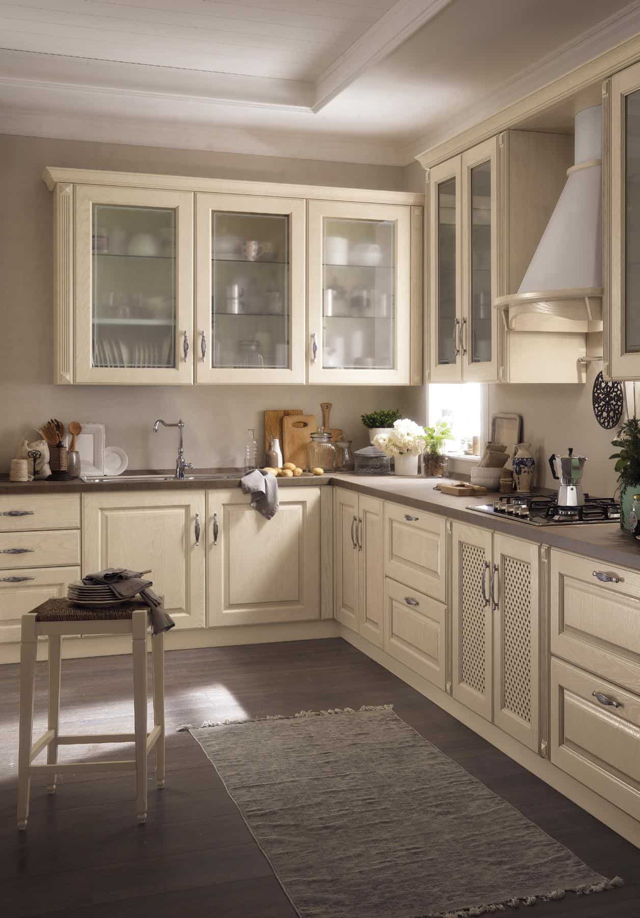 Traditional kitchen with light wood cabinets, glass-front upper cabinets, and a dark wood floor.