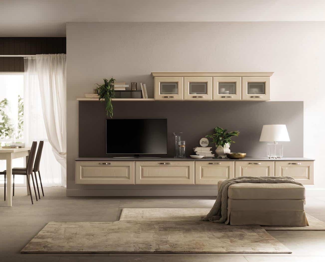 Modern living room with a wall-mounted TV unit, beige cabinetry, decorative plants, and a lamp, adjacent to a dining area.