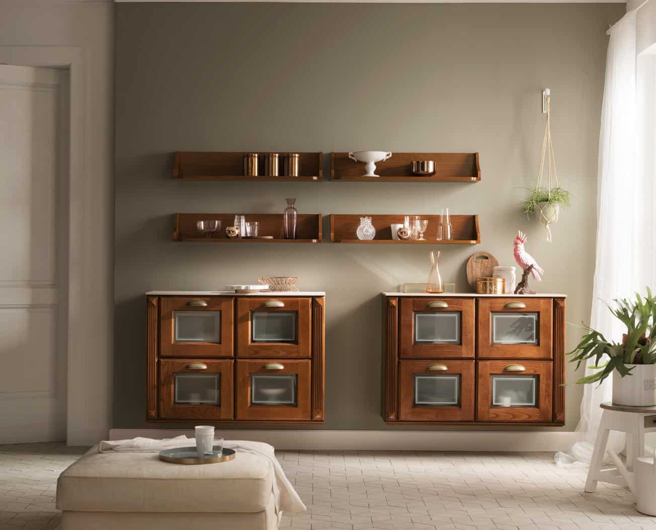 A living room with two wooden cabinets mounted on the wall, floating shelves above displaying various decorations, a hanging plant, and a cushioned ottoman in front.
