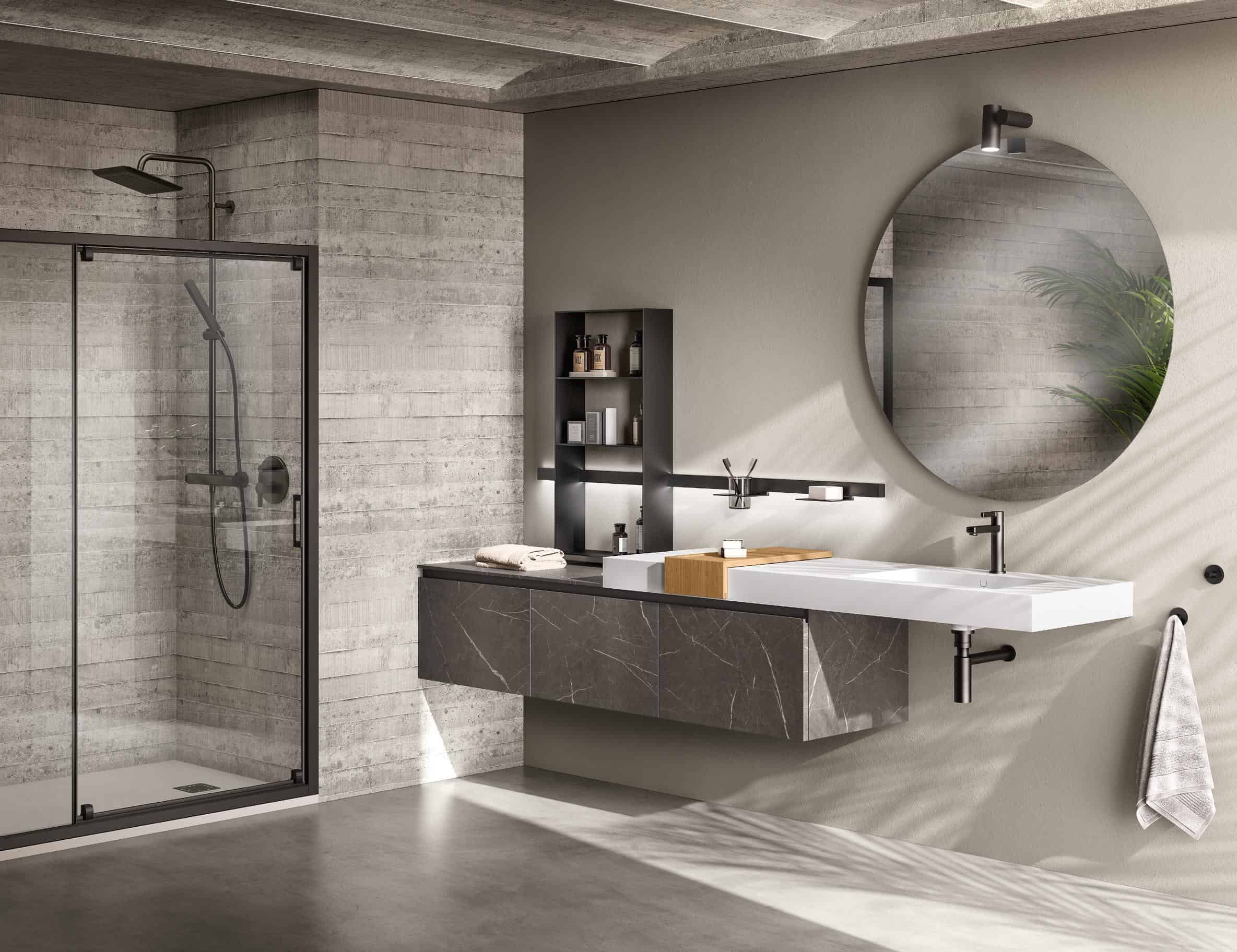 Modern bathroom with a concrete tile shower, glass door, wall-mounted sink, large round mirror, black shelving, and a gray towel on a hook.