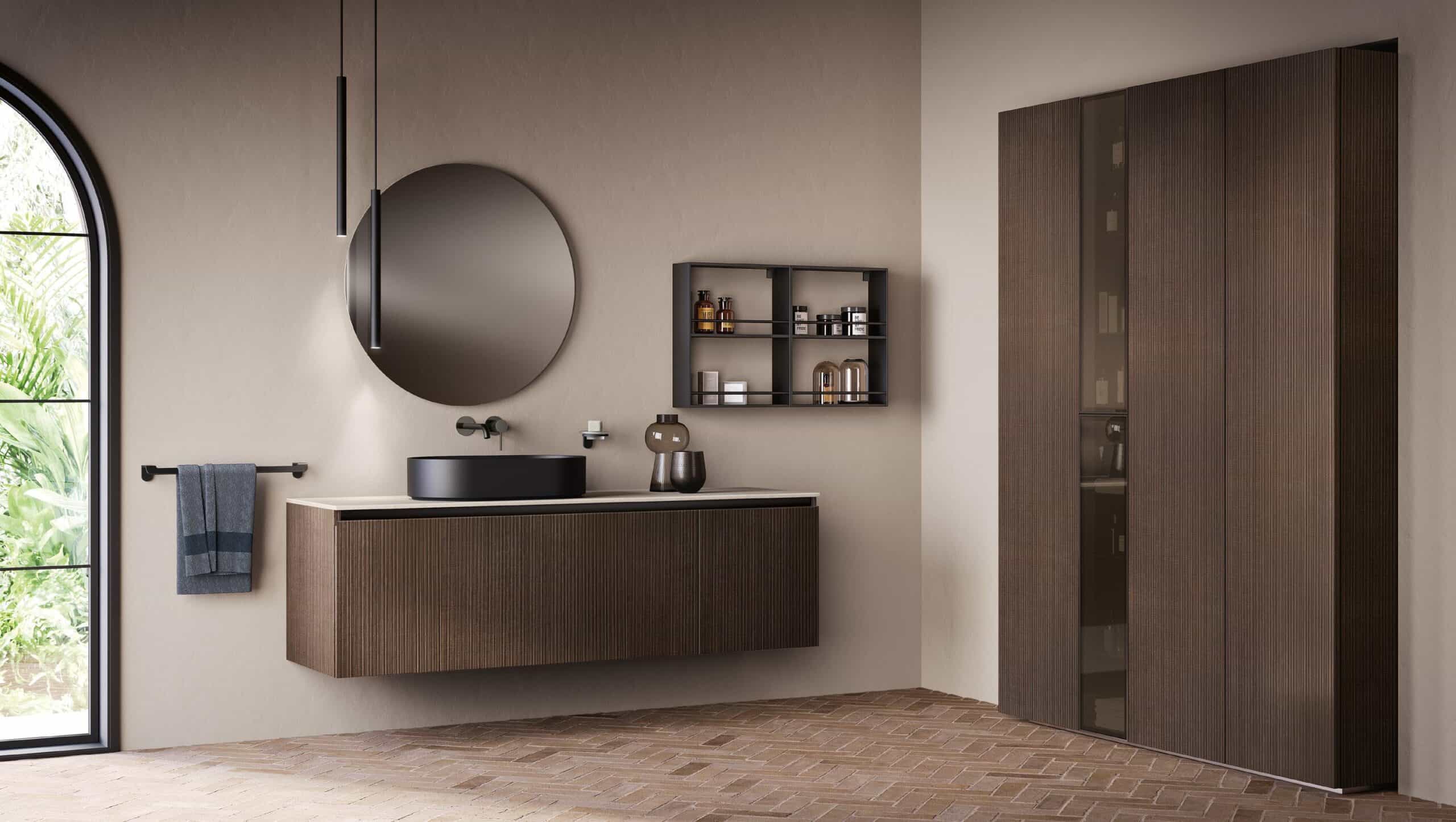 Modern bathroom with a floating wooden vanity, round mirror, black sink, and open shelving, featuring a large wardrobe and a window with a view of greenery.
