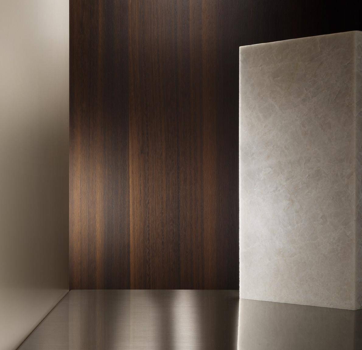 Minimalist interior with a dark wooden wall and a smooth beige marble surface.