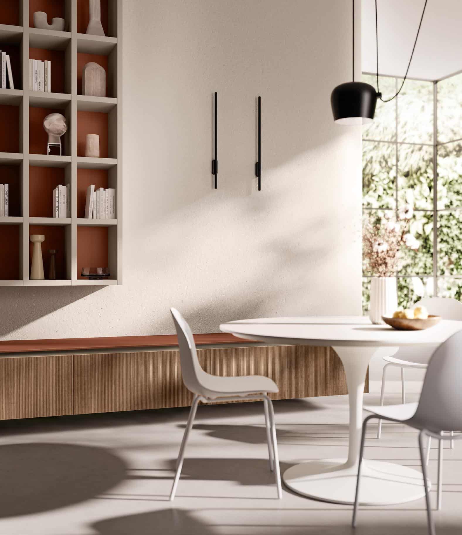 Modern dining area with a round white table, white chairs, built-in shelving with decorative items, and a large window providing natural light.