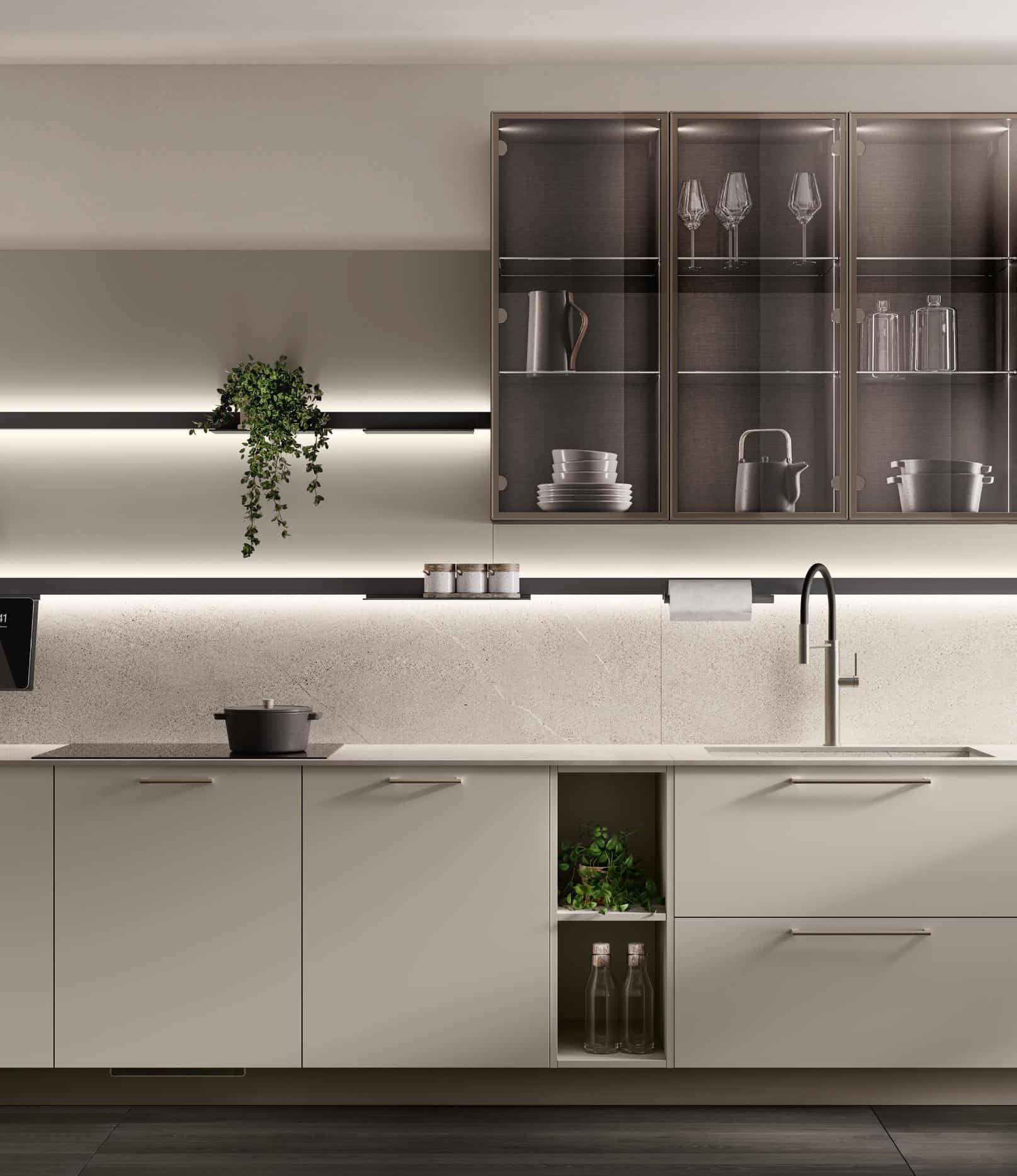 Modern kitchen interior with light gray cabinetry, glass wall cabinets displaying glassware, under-cabinet lighting, countertop with a pot, and a sleek faucet.