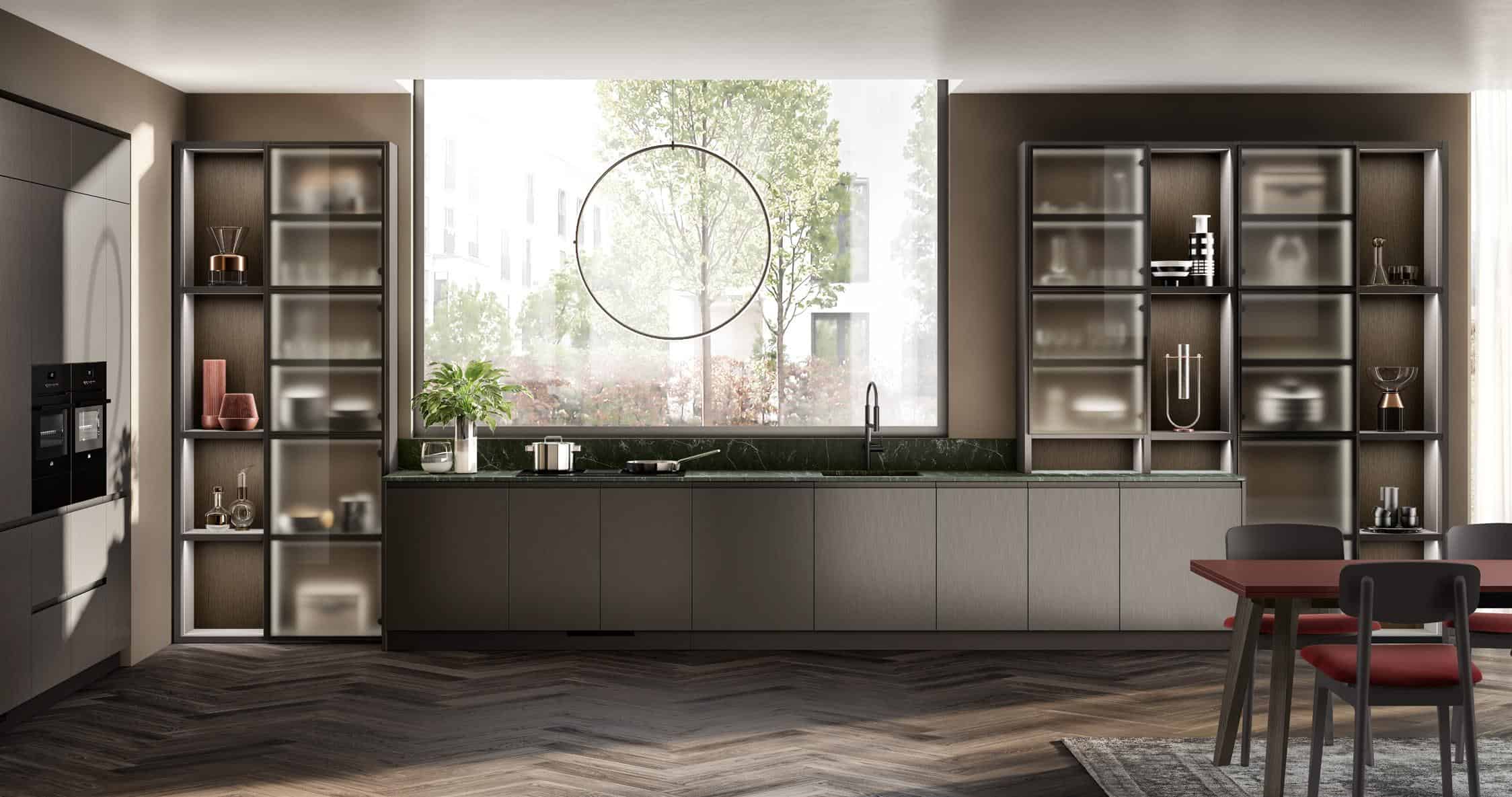 "Modern kitchen with sleek grey cabinets, large window with a circular accent, green marble countertop, open shelving, and a dining area with red and black chairs."