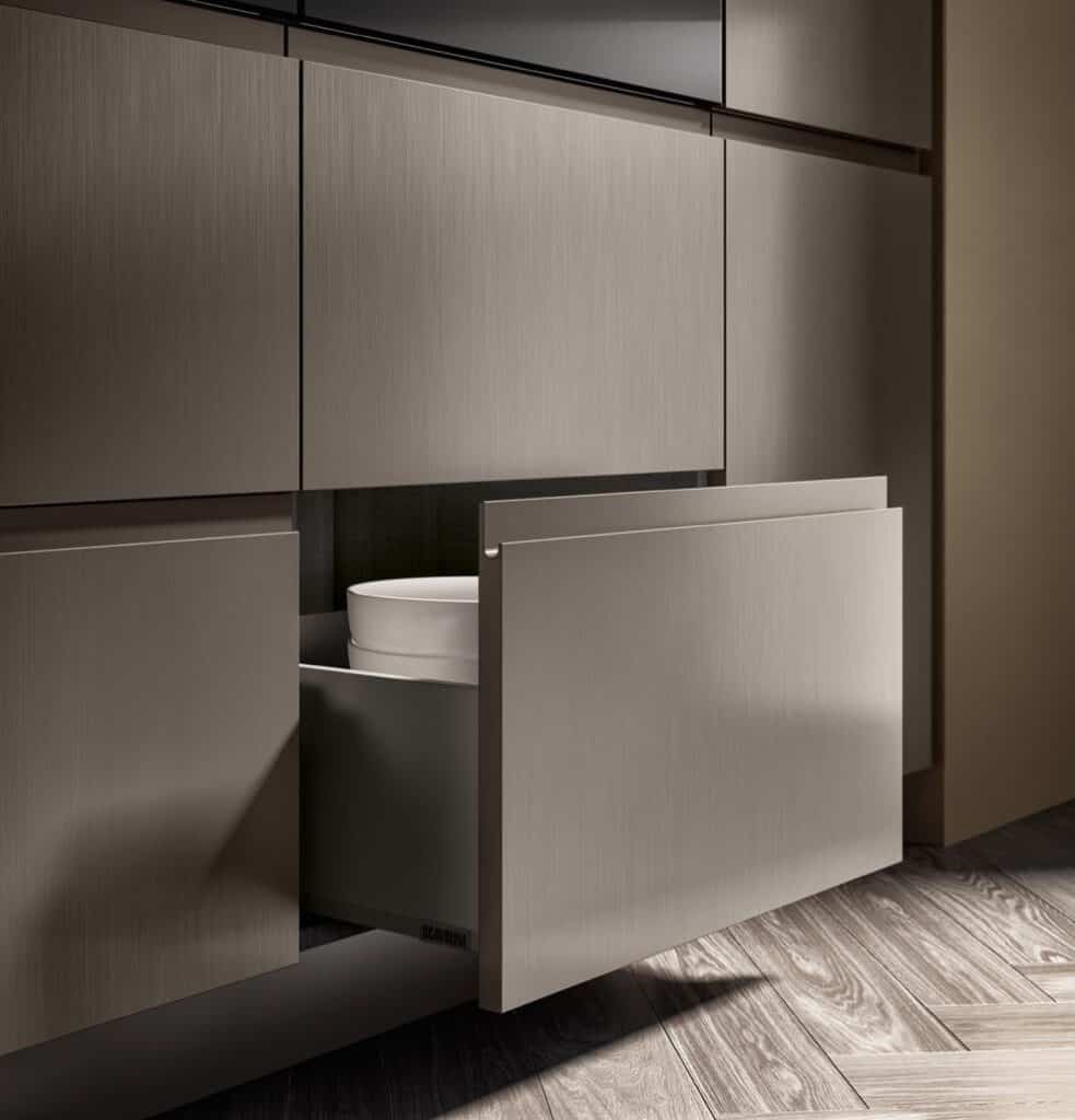 A modern kitchen cabinet with a partially open drawer revealing a white bowl inside.
