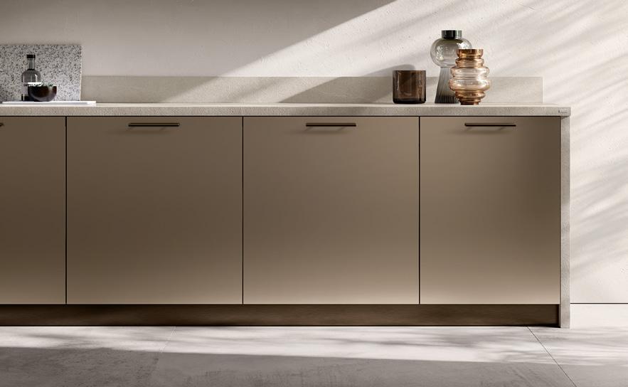 Modern kitchen cabinets with a minimalist design, featuring light brown doors and a speckled countertop.