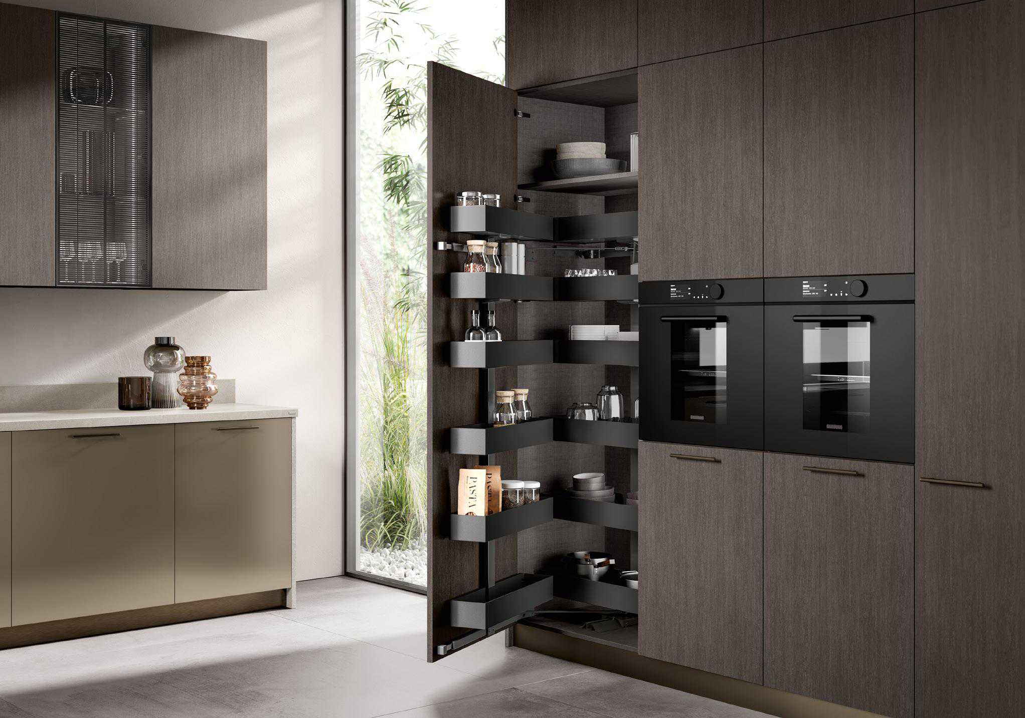 Modern kitchen with dark wood cabinets, two built-in ovens, and an open pantry with black shelving.
