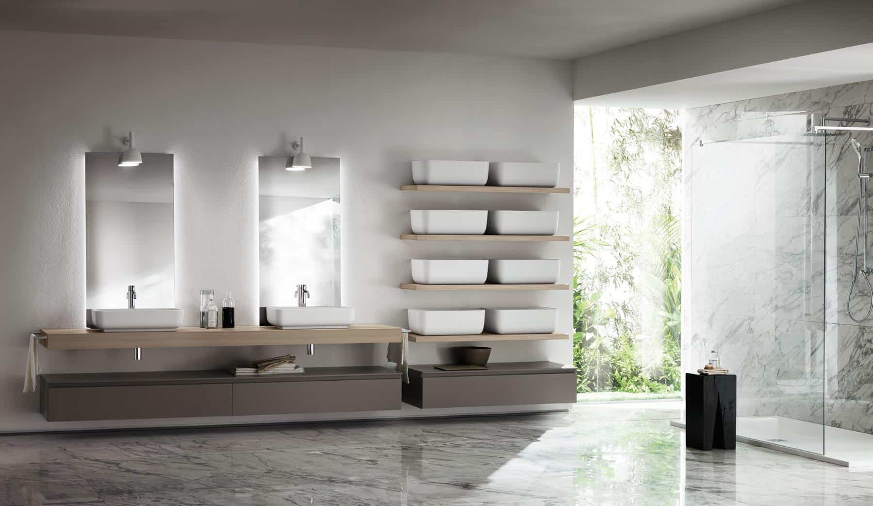 Modern bathroom with a double sink vanity, large mirrors, wall-mounted shelves with white containers, and a glass shower enclosure; features marble flooring and walls, with greenery visible through an open window.