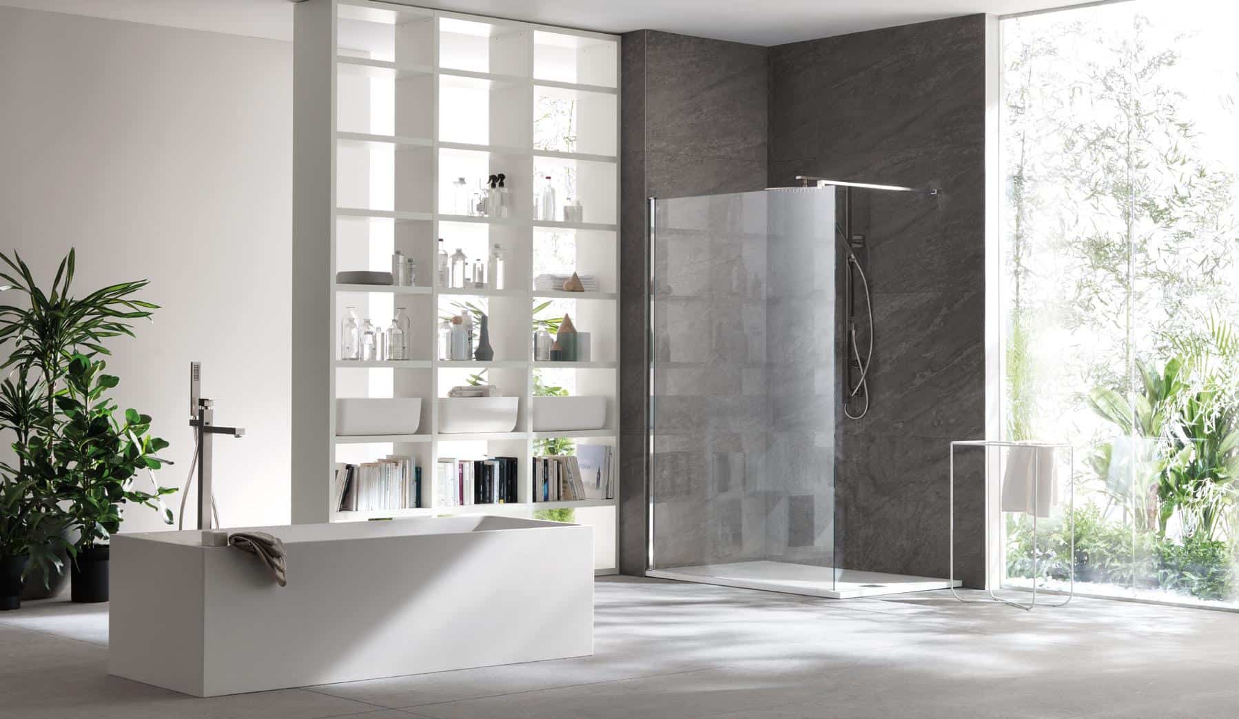 Modern bathroom with a freestanding bathtub, glass shower, shelving unit, and large window with a view of greenery.