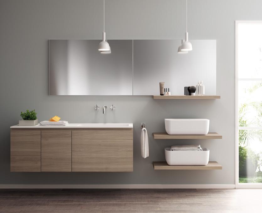 Modern bathroom with floating wooden cabinetry, large mirror, two pendant lights, shelves with toiletries, and two rectangular sinks.