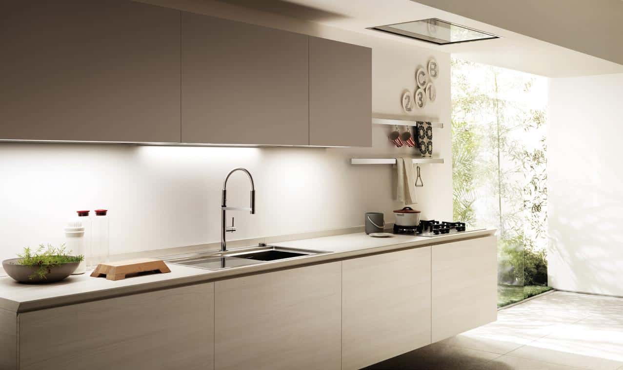 Modern kitchen with sleek cabinetry, a large window, a minimalist countertop, and a built-in stove and sink.