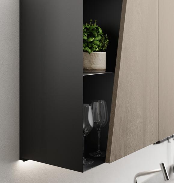 A modern kitchen cabinet with a partially open door, revealing wine glasses and a potted plant inside.