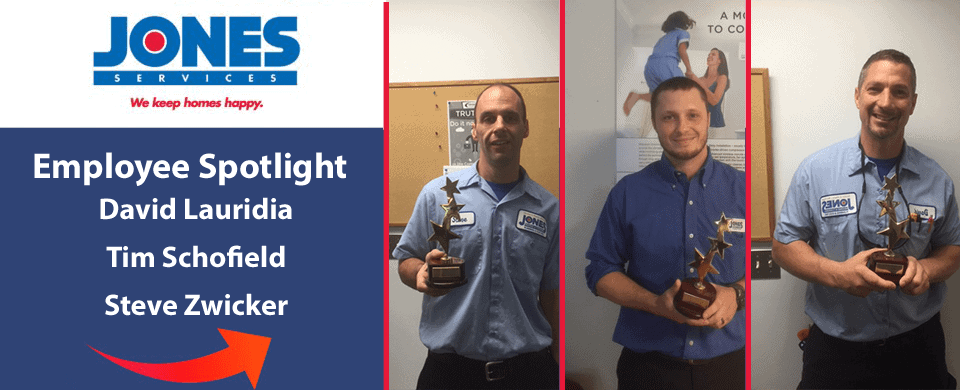 Three employees from Jones Services holding awards. Sign reads "Employee Spotlight: David Lauridia, Tim Schofield, Steve Zwicker." Red arrows emphasize award recipients.