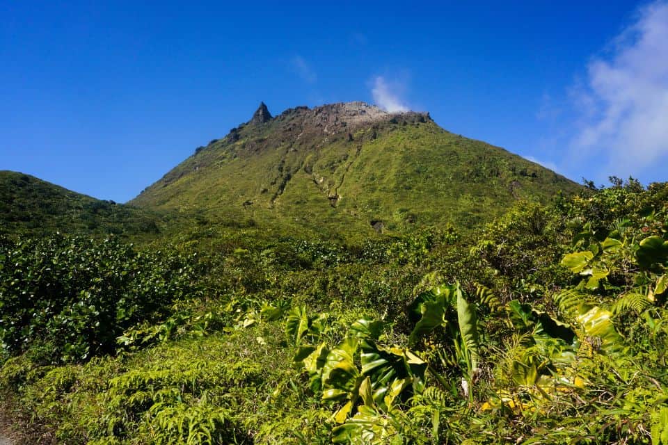 Vue sur le sommet du volcan La Soufrière en Guadeloupe avec nuages et sentier de randonnée