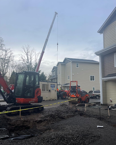 Legacy Paving crews install new asphalt, working safely behind caution tape at a busy apartment construction site.