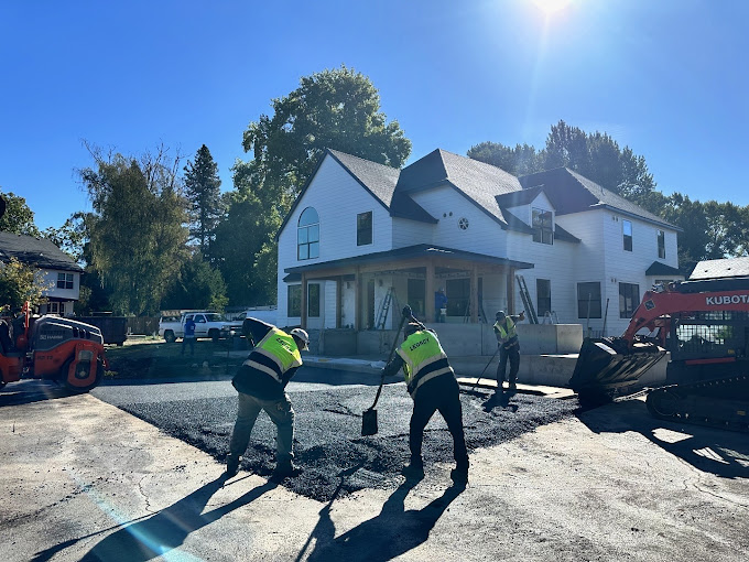 Legacy Paving workers make a new driveway in front of a big house, showing teamwork and quality paving service.