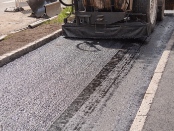 A Legacy Paving expert uses a machine to make an old road look brand new and smooth for safe and easy driving.