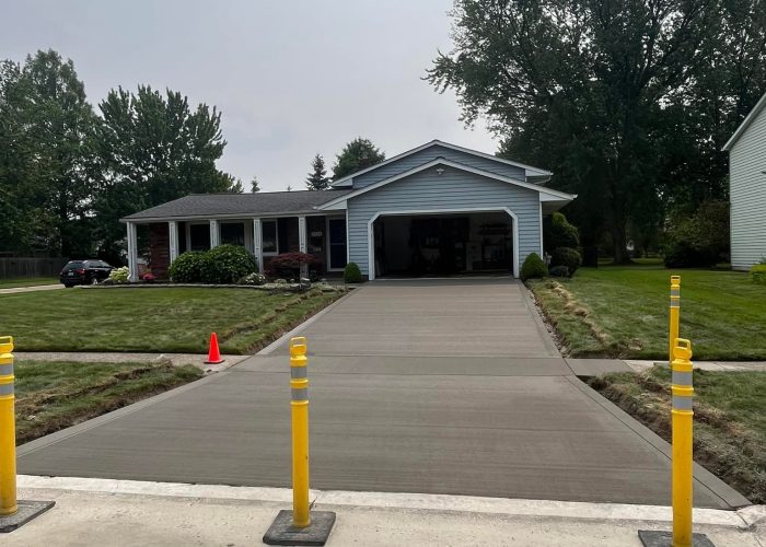 A new concrete driveway by Legacy Paving shows quality work and is closed off to keep it safe while it dries.