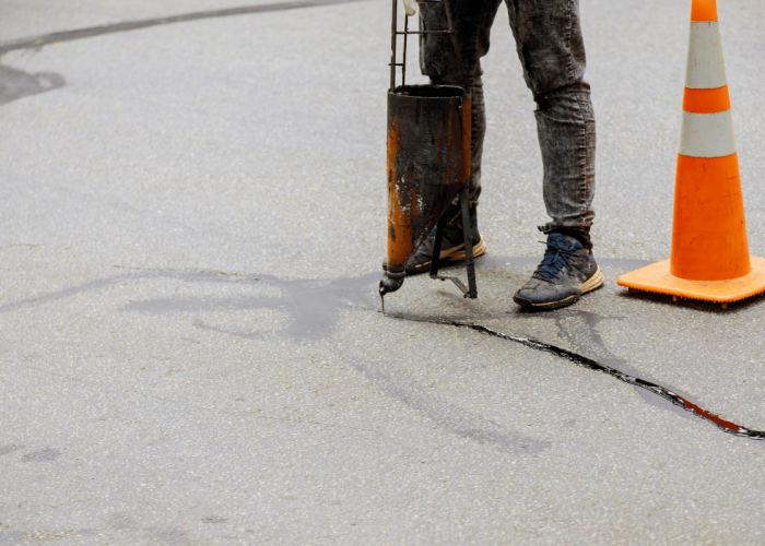 A Legacy Paving worker repairs a road crack using professional tools, showing skilled paving services that help keep roads safe and smooth.