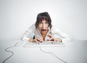 Scared woman hitting keyboard at her desk