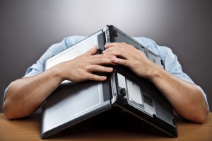 Exhausted businessman with computer on head