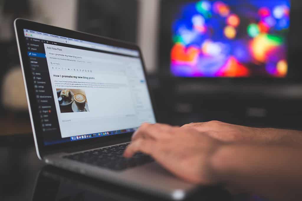 a writer typing with an up close image of their computer screen and blog post