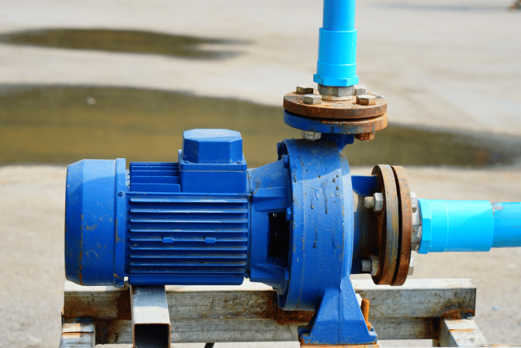 A water well pump and pipes working together to provide clean water as part of a professional well drilling service.