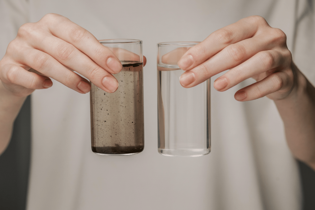 Person shows difference between clean water from a good well and dirty water, highlighting the importance of safe wells.