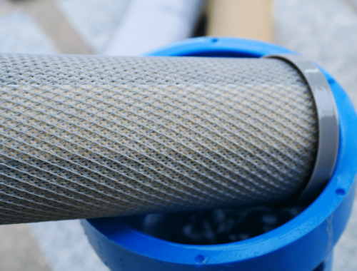 A water filter being put in place helps keep well water clean and protects the well pump for McCandless Well Drilling and Services.