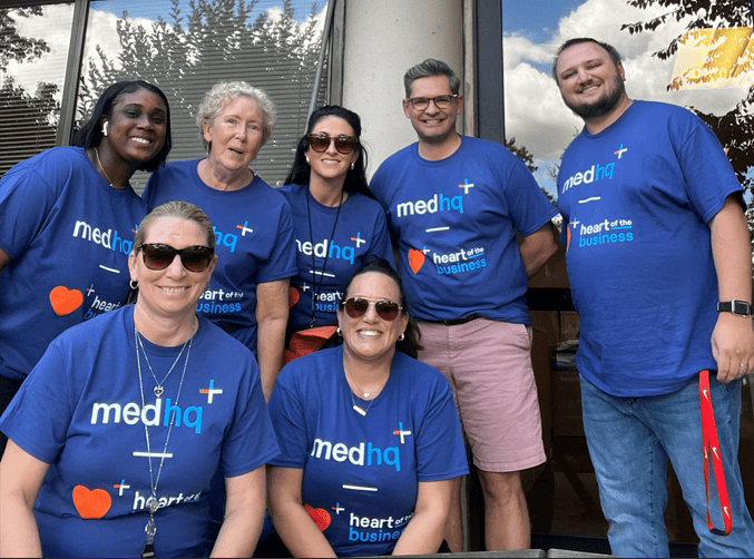 seven medHQ team members wearing their Heart of the Business shirts