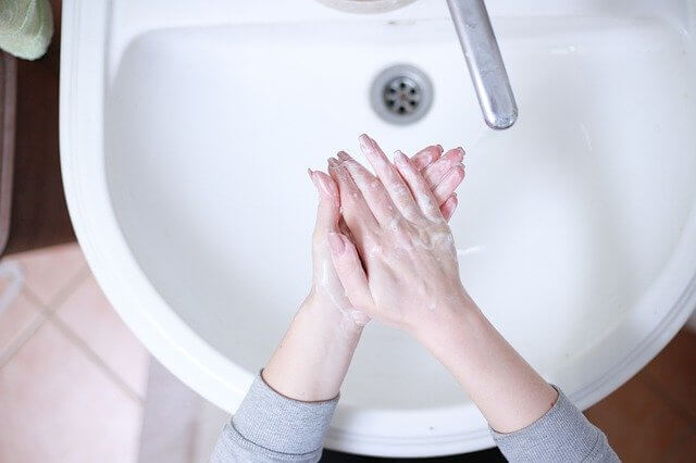 A person washes hands with soap in a clean sink, showing how Mid State Baths values good hygiene and cleanliness at home.