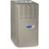 Gray Carrier furnace, standing upright with vent grilles on top, featuring the Carrier logo on the front panel.