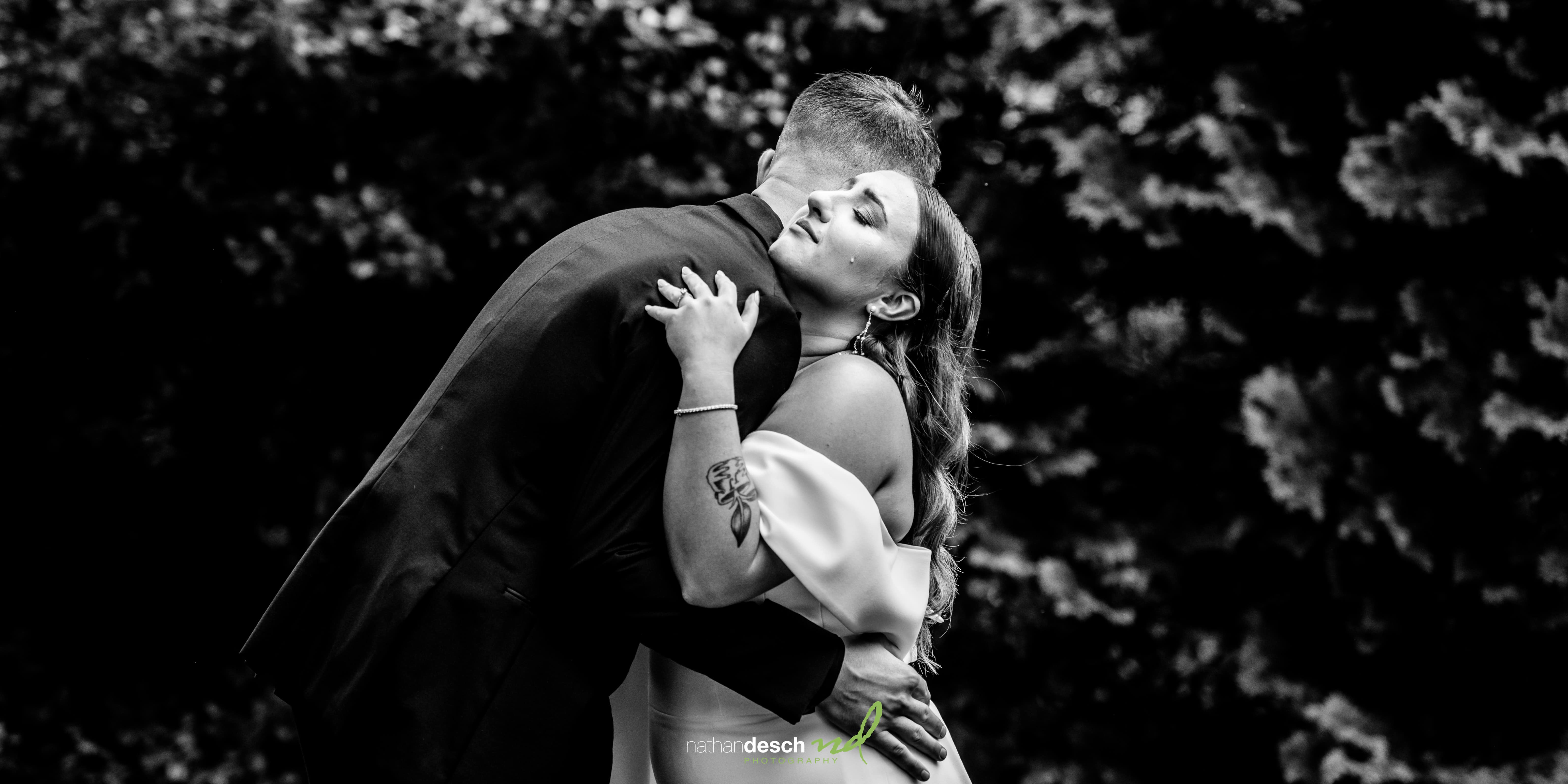 bride with tear on face hugging groom