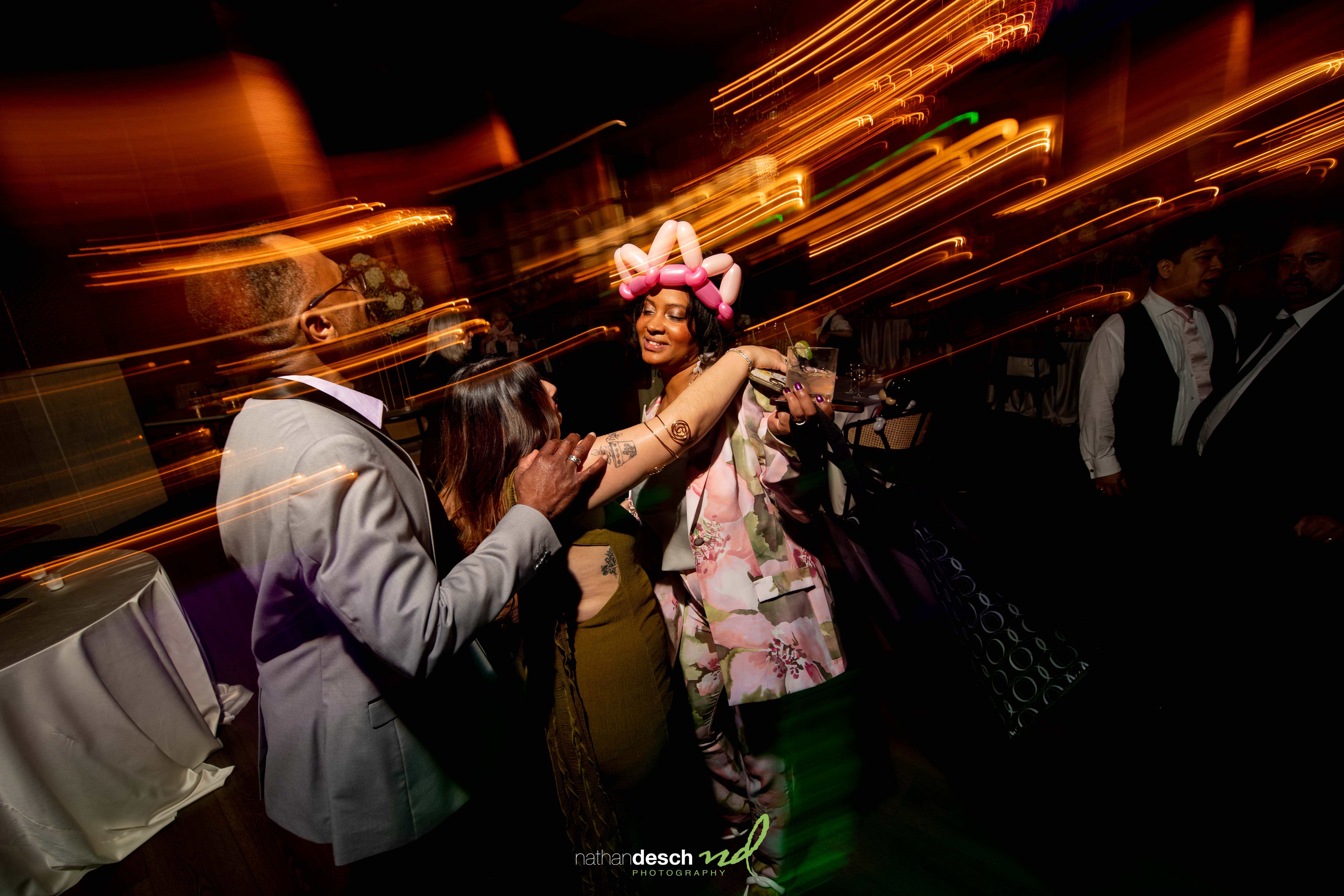 Three guests dancing at Tendenza spring wedding, with balloon crown and colorful motion blur for a festive vibe.
