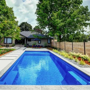 A peaceful backyard retreat features The Pinnacle pool by Northern Colorado Pools, designed for easy care and relaxation.