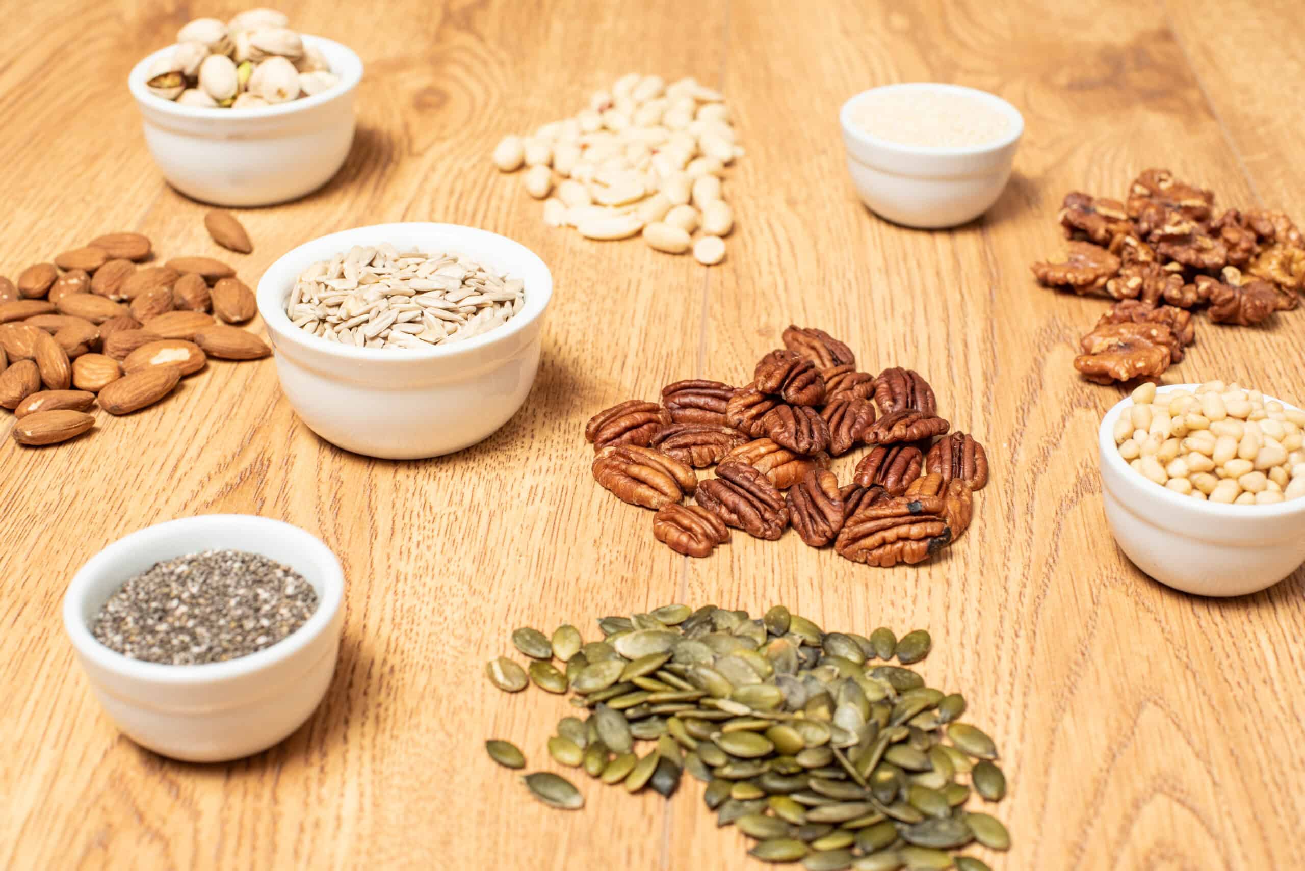 Nuts and seeds on a table A variety of nuts and seeds arranged on a wooden table