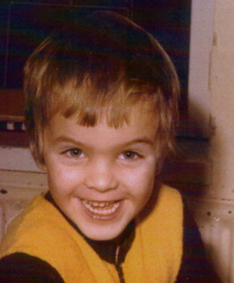 Smiling young boy in a yellow sweater, early photo of Martin Kantola
